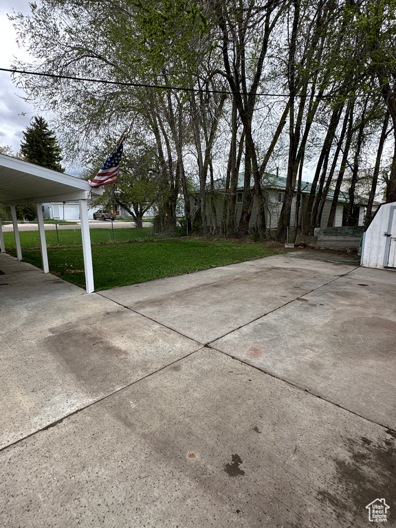 View of grassy yard featuring a storage unit