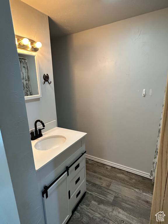 Full bathroom with vanity and wood finished floors