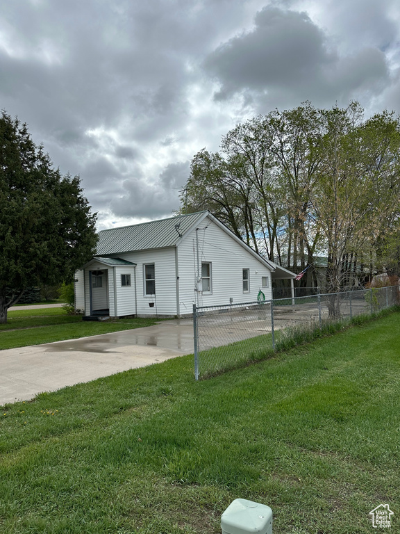 View of side of home featuring metal roof and driveway