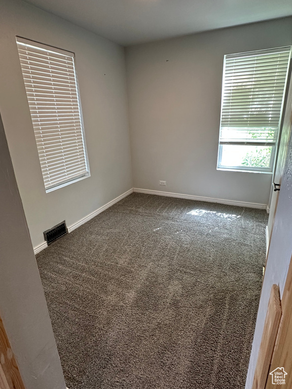 Unfurnished room featuring carpet and baseboards