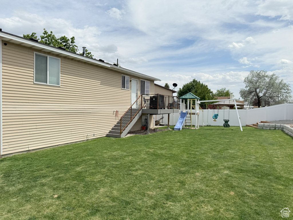View of yard featuring a playground, stairway, and a deck