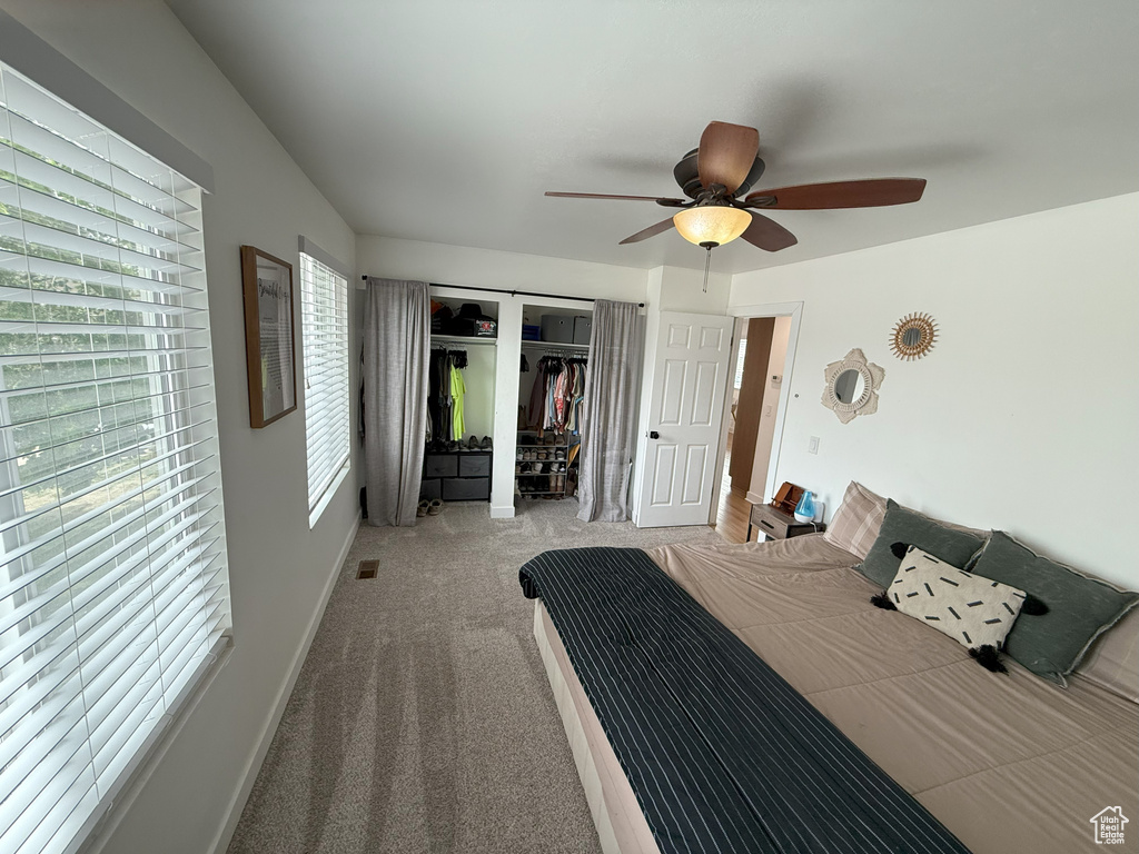 Carpeted bedroom featuring a closet and ceiling fan