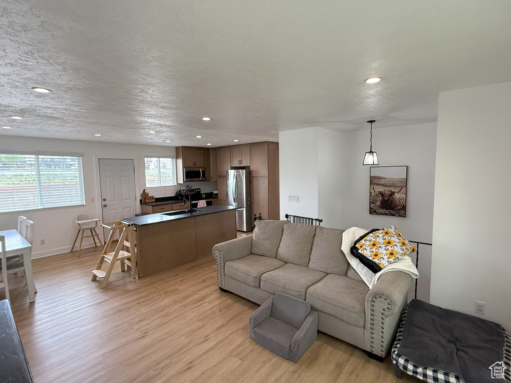 Living room featuring light wood-type flooring, recessed lighting, and baseboards
