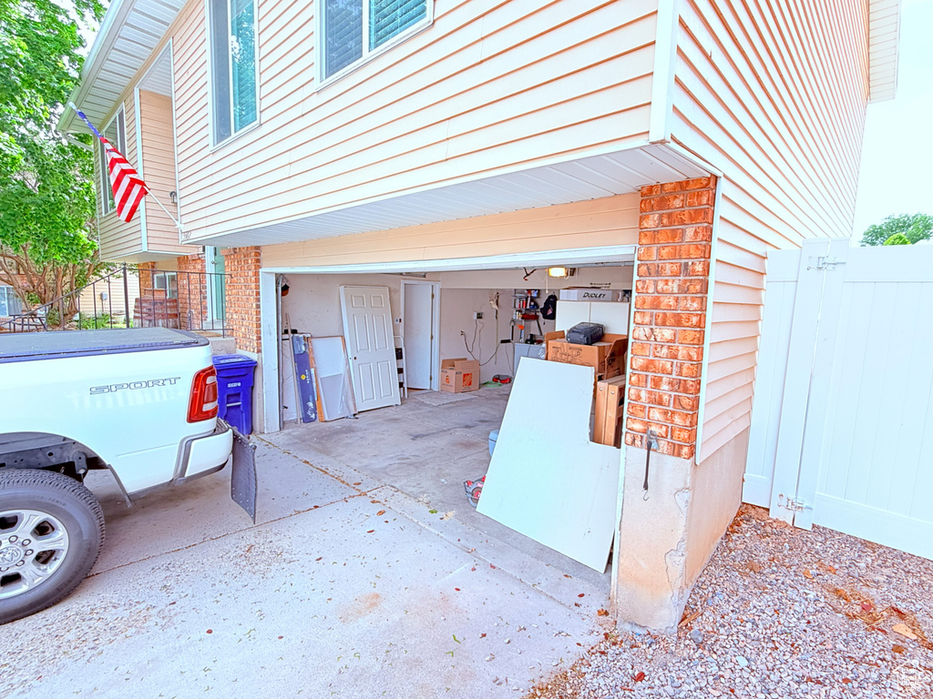 Garage featuring fence and driveway