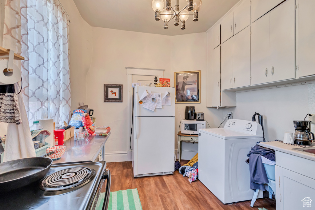 Washroom with washer / dryer, a chandelier, and light wood-style floors