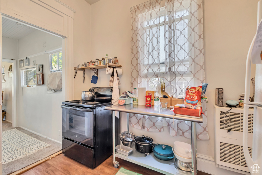 Kitchen featuring black / electric stove and light wood-style flooring