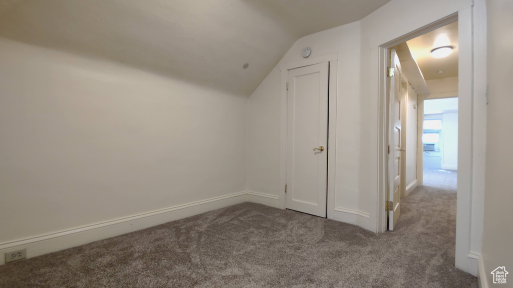 Additional living space with carpet flooring and lofted ceiling
