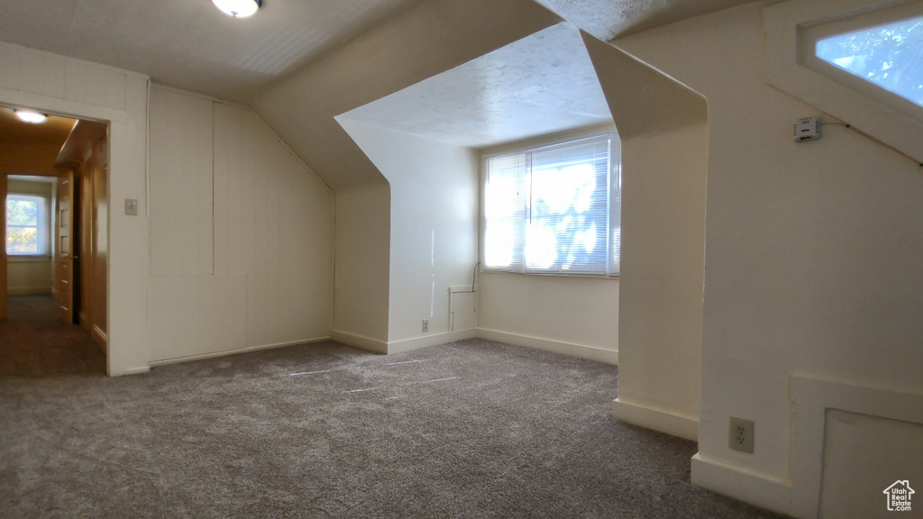 Bonus room with vaulted ceiling, carpet flooring, and baseboards