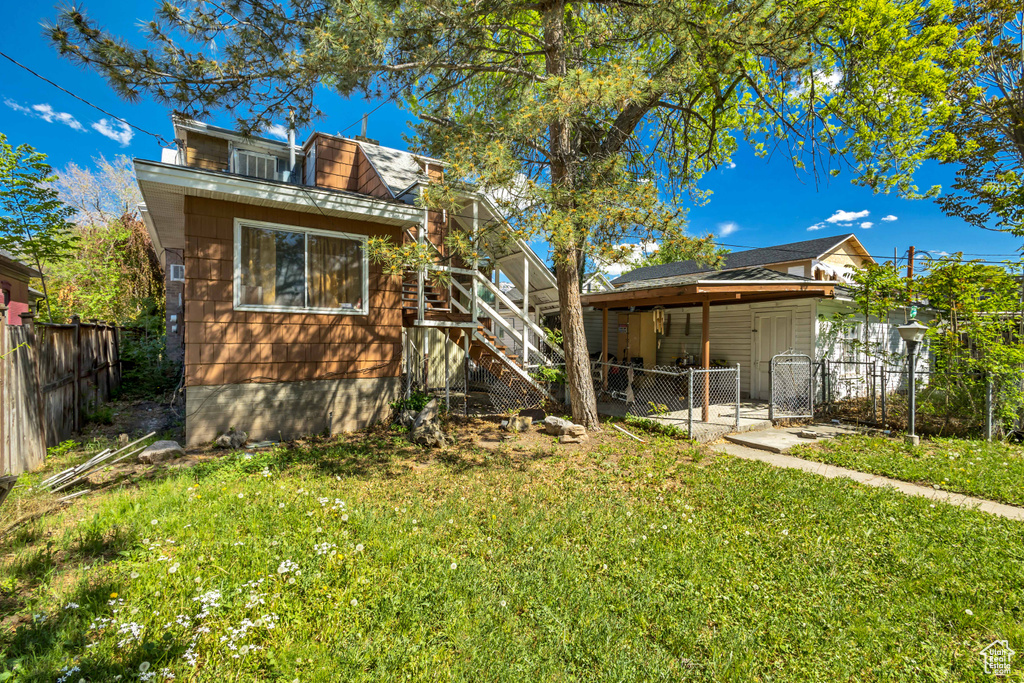 Back of property featuring a gate and stairs