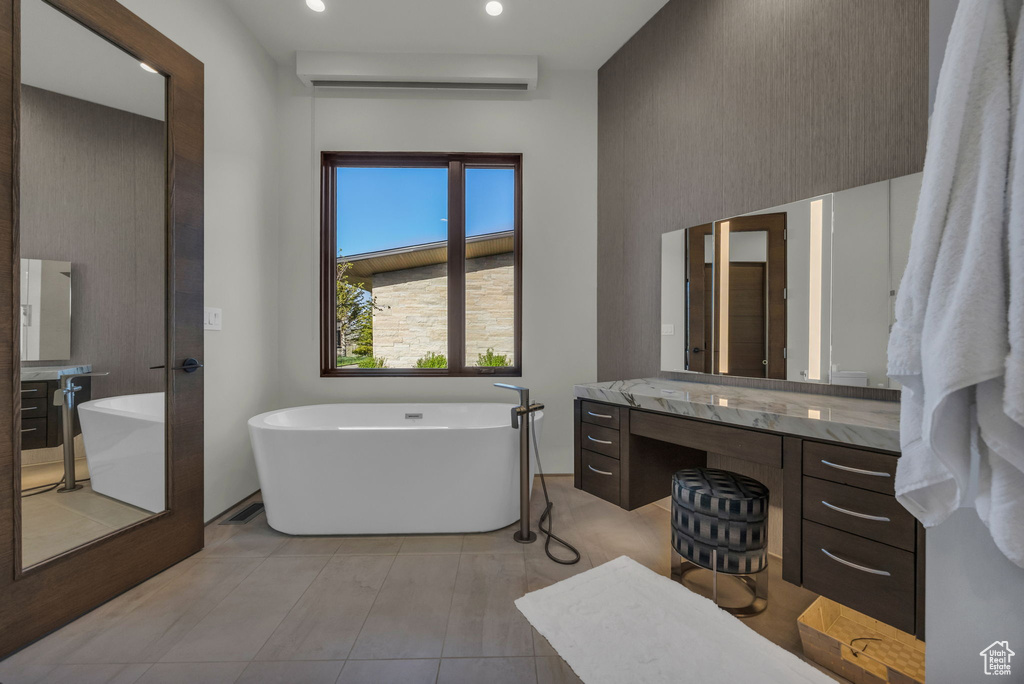 Bathroom with vanity, a freestanding tub, recessed lighting, and a wall unit AC