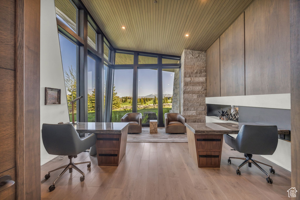 Office area featuring floor to ceiling windows, plenty of natural light, wood ceiling, and wood finished floors
