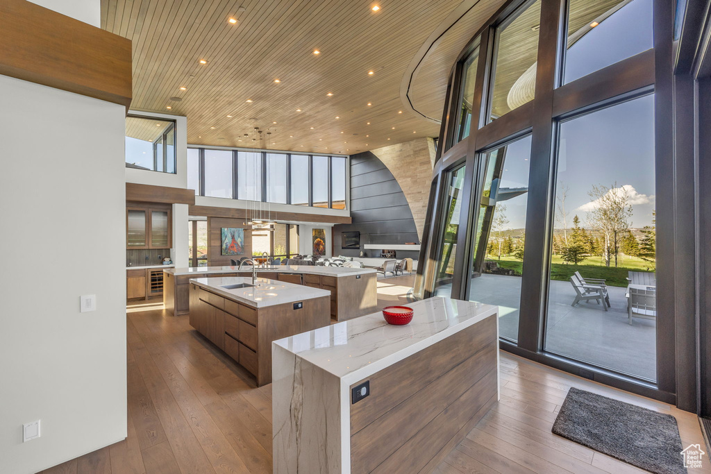 Kitchen with a large island, modern cabinets, a towering ceiling, hardwood / wood-style flooring, and wood ceiling