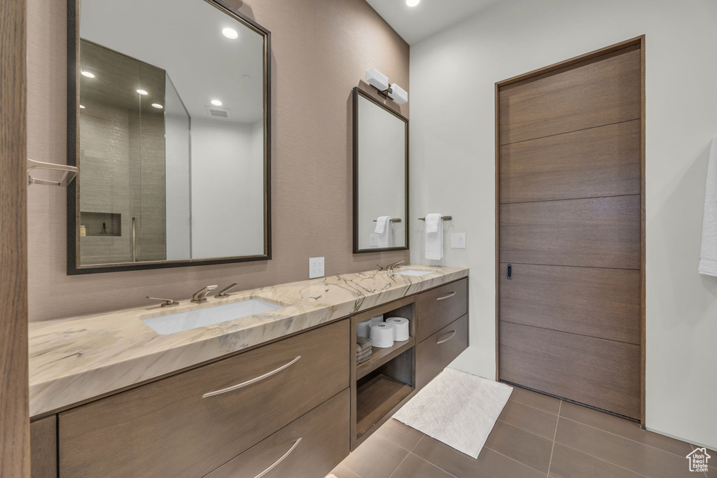 Bathroom with tile patterned floors, double vanity, and recessed lighting