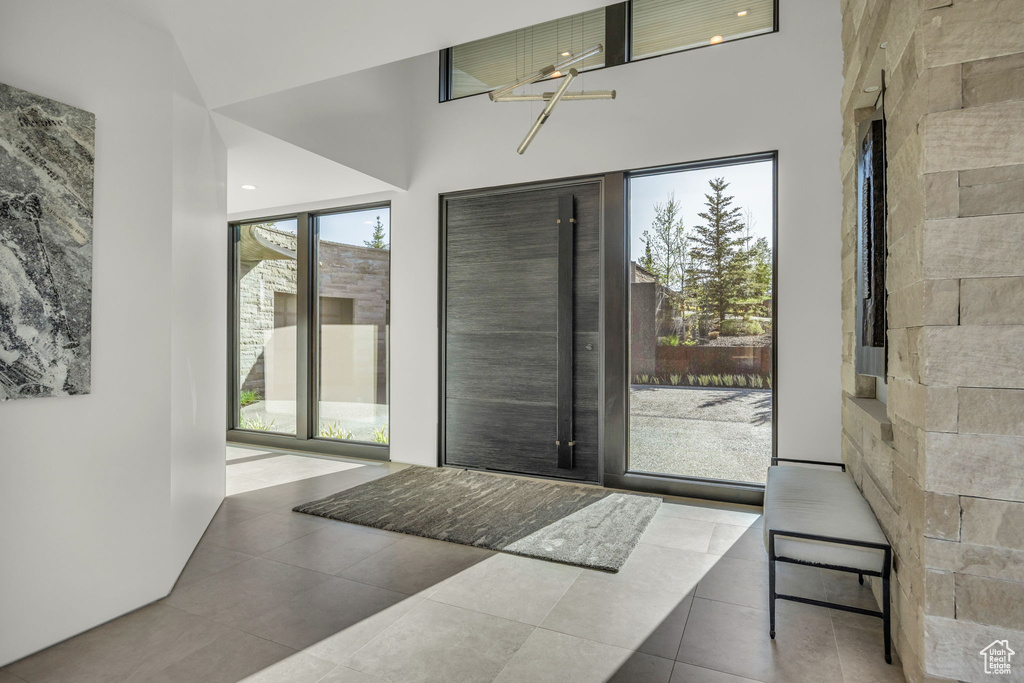 Doorway with tile patterned flooring and a high ceiling