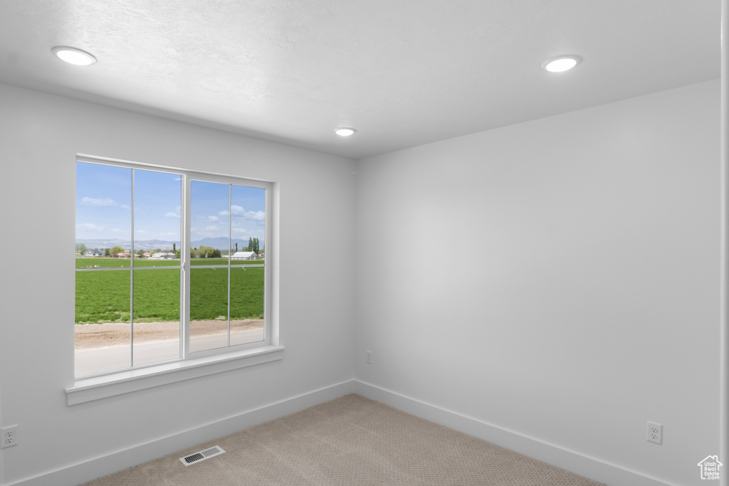 Spare room with baseboards, light carpet, and recessed lighting