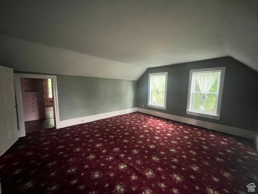Bonus room with lofted ceiling, carpet floors, and baseboards