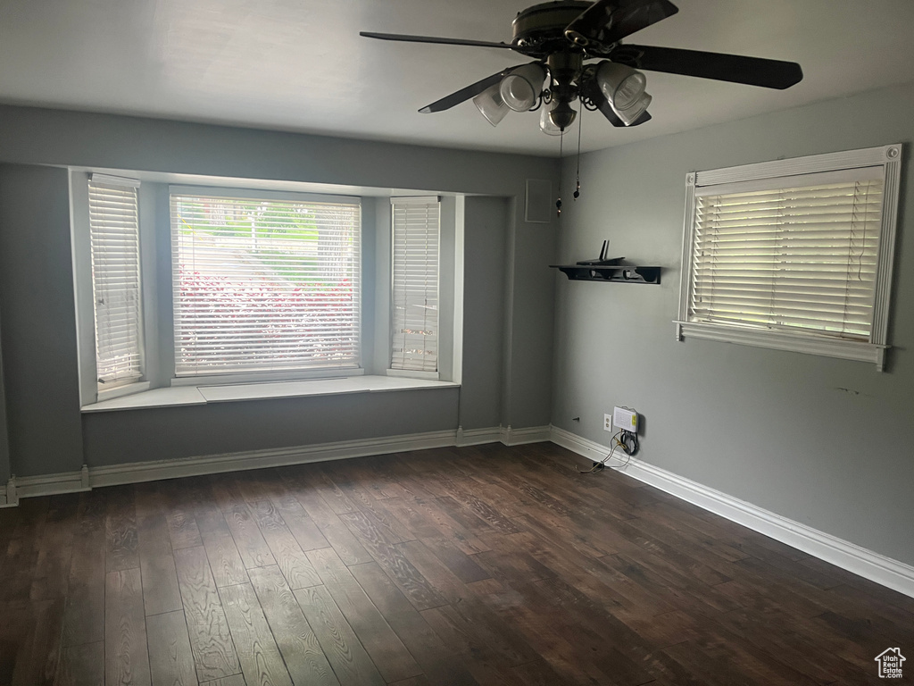 Empty room featuring a ceiling fan, wood finished floors, and baseboards