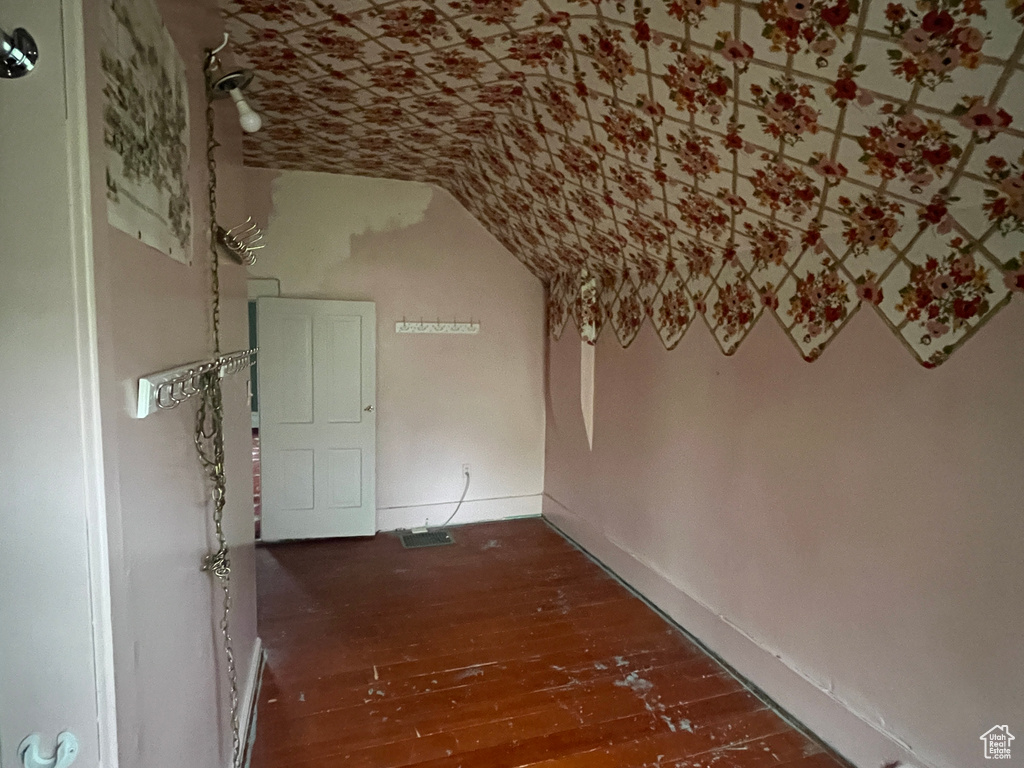 Hallway featuring lofted ceiling and hardwood / wood-style floors