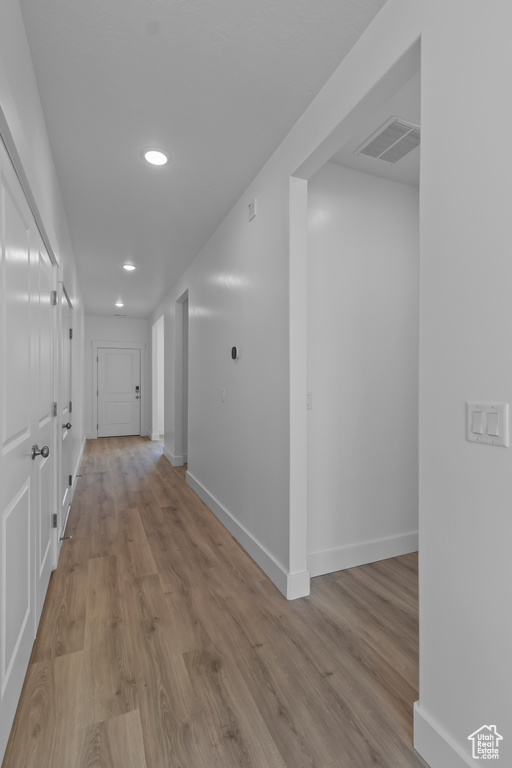 Corridor featuring recessed lighting, baseboards, and wood finished floors