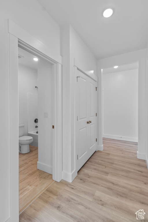 Corridor featuring light wood finished floors and baseboards