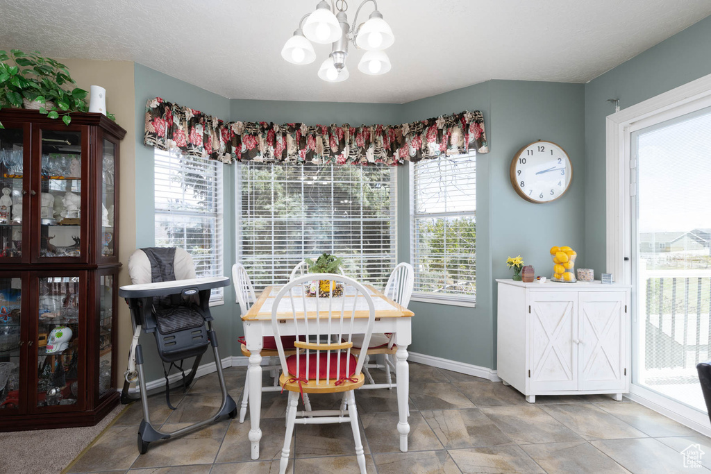 Dining room featuring a chandelier and baseboards