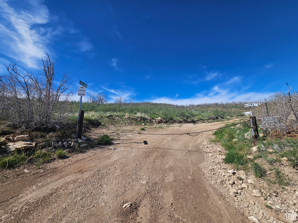 View of dirt / gravel road featuring a view of rural / pastoral area