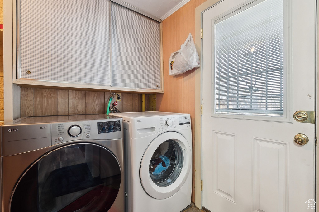 Washroom featuring cabinet space, separate washer and dryer, and crown molding