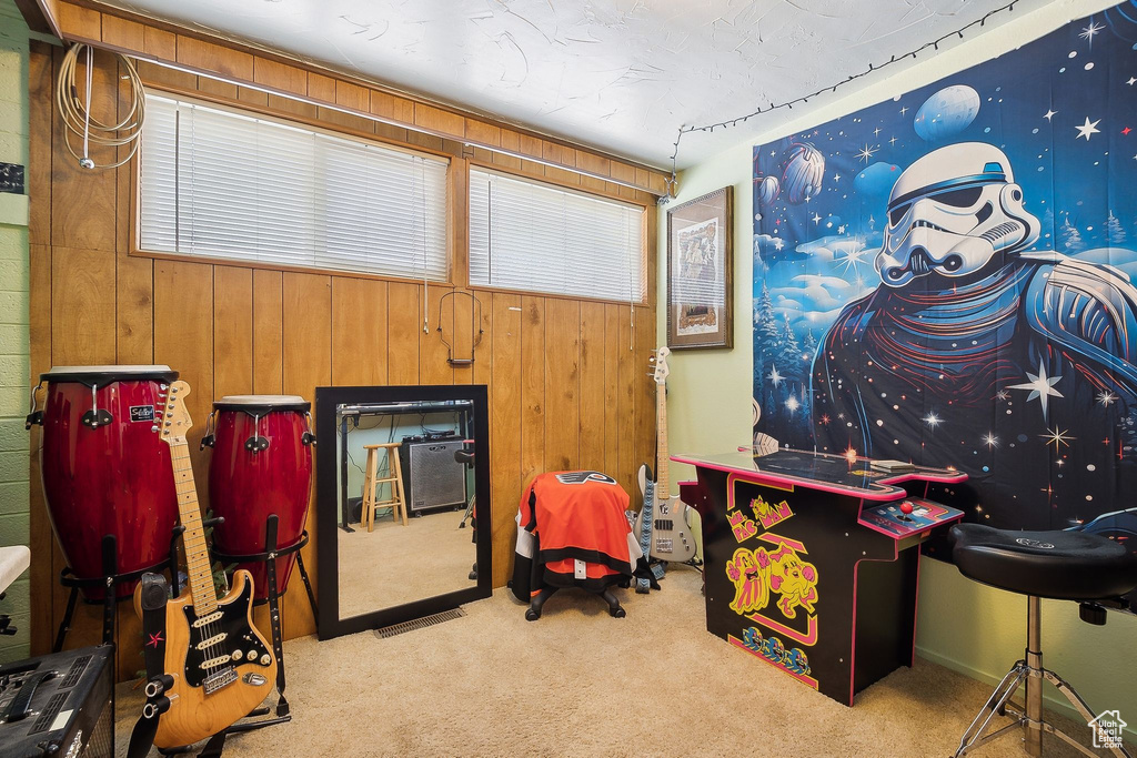 Game room with carpet floors, wooden walls, and healthy amount of natural light