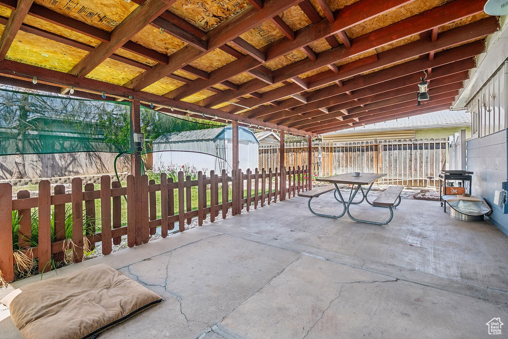 View of patio featuring a fenced backyard, a storage unit, and an outbuilding
