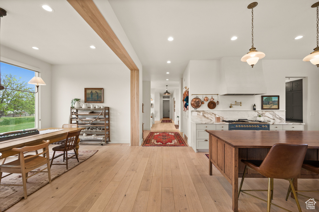 Kitchen featuring gas stove, light wood-type flooring, white cabinetry, tasteful backsplash, and recessed lighting