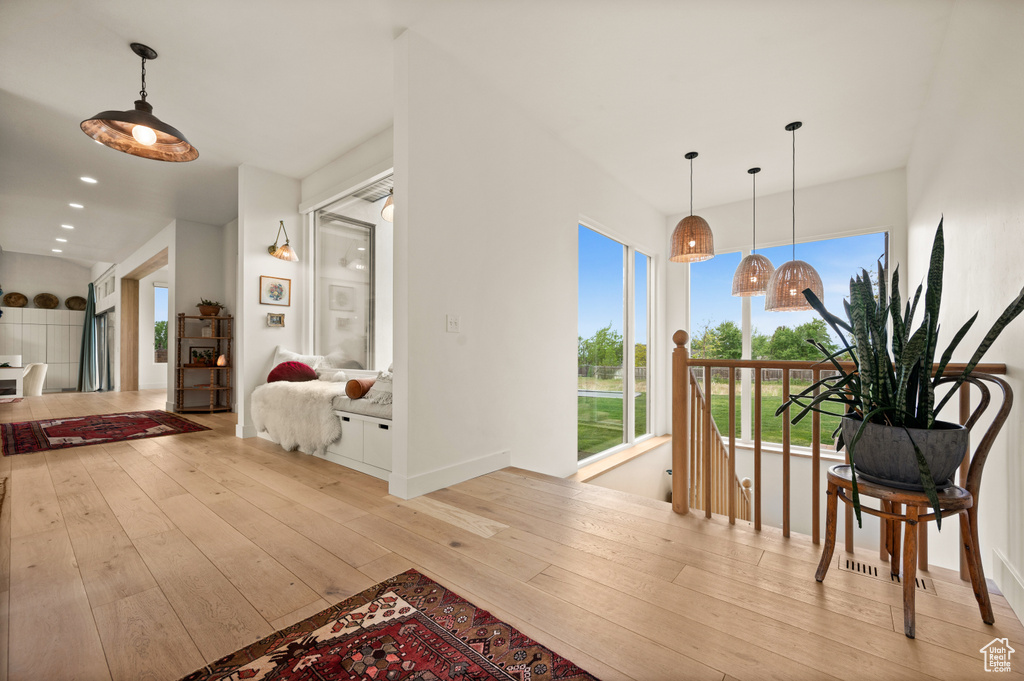 Hall featuring hardwood / wood-style flooring, healthy amount of natural light, an upstairs landing, and recessed lighting