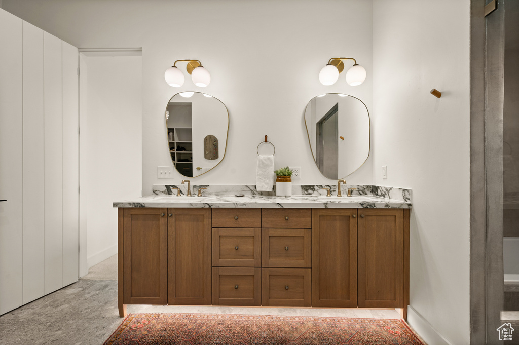 Bathroom with double vanity and baseboards