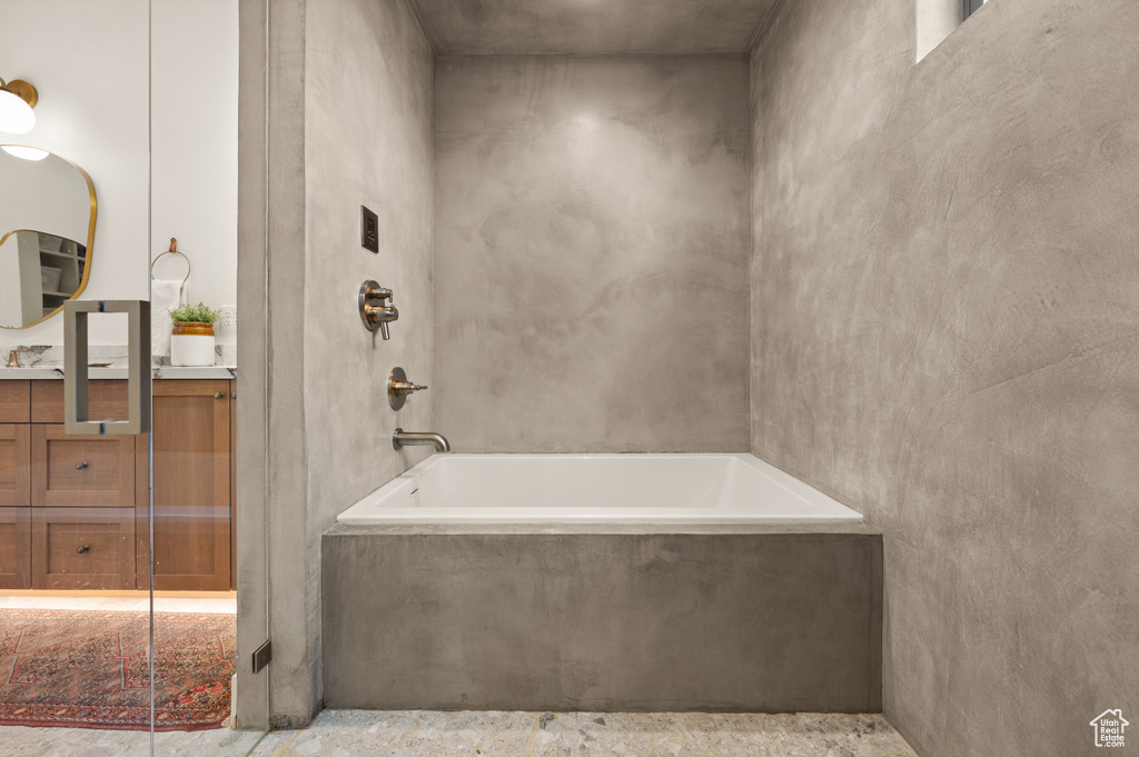 Bathroom with a tub with marble appearance, vanity, and a shower