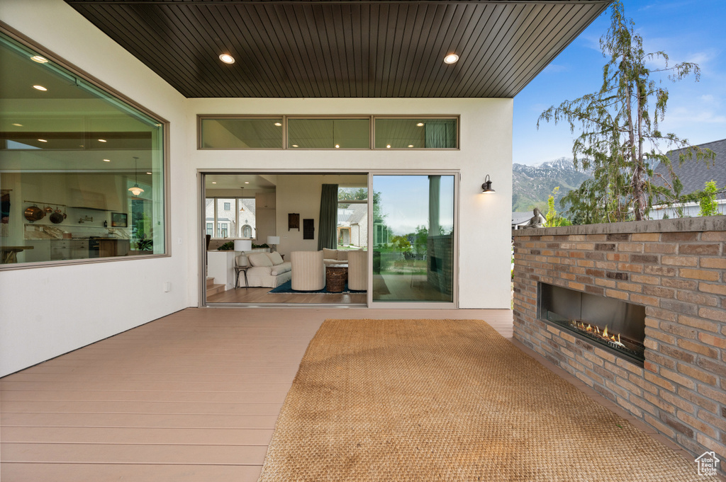 View of patio with an outdoor brick fireplace and a mountain view
