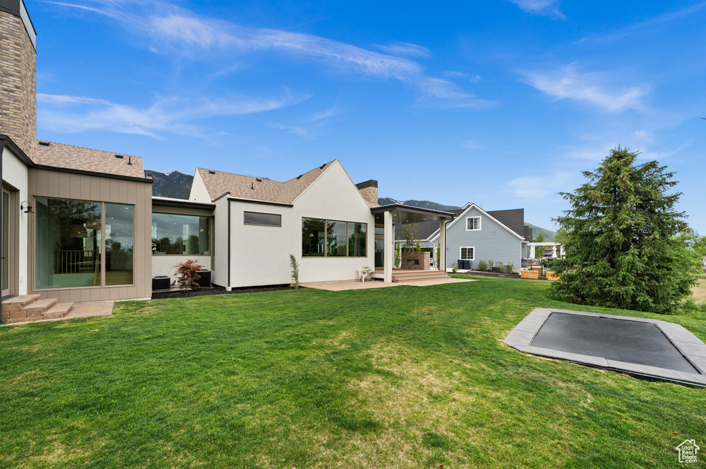 Rear view of house featuring a lawn and a patio area