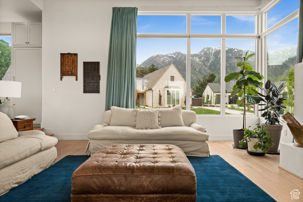 Living area featuring a mountain view, wood finished floors, and baseboards