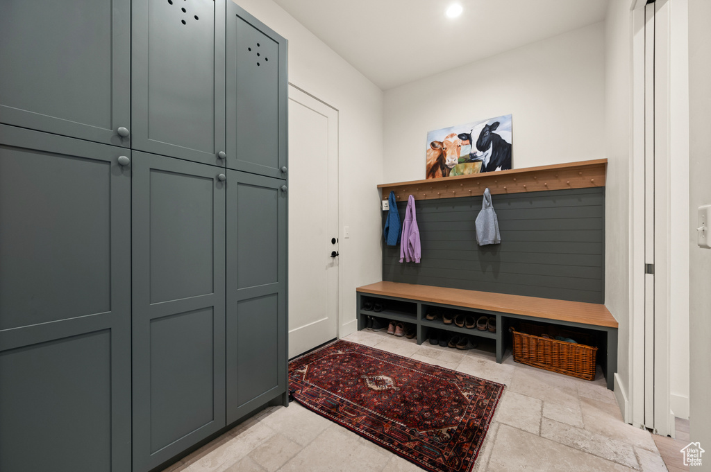Mudroom with stone tile floors and baseboards
