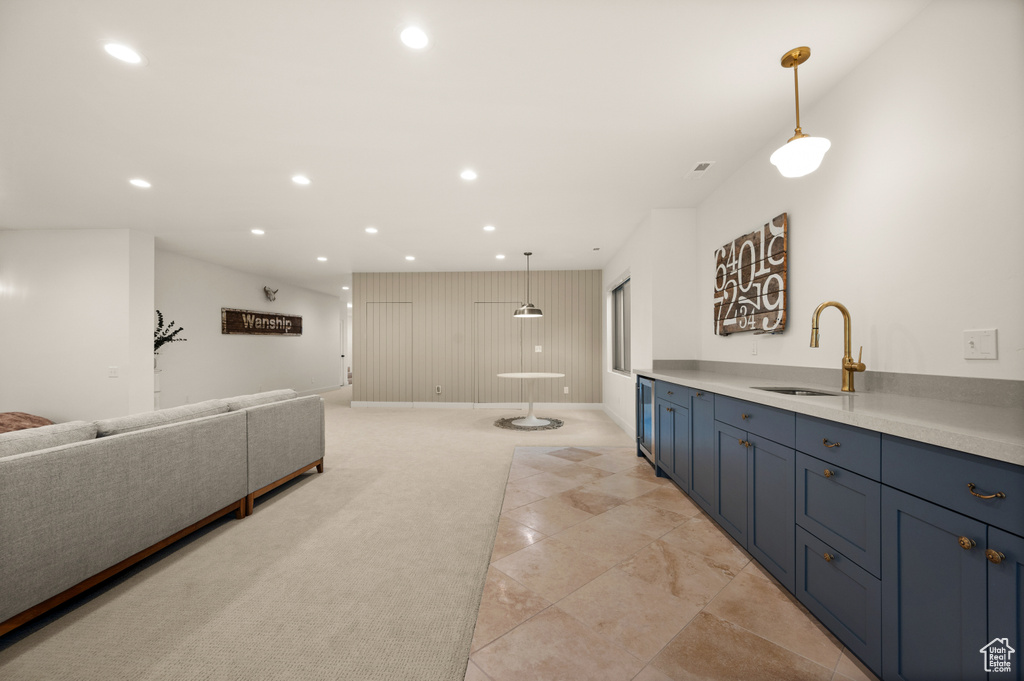 Kitchen featuring a sink, recessed lighting, light carpet, blue cabinets, and open floor plan
