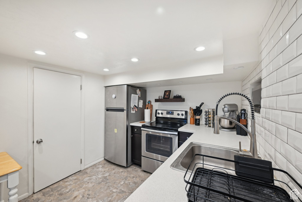 Kitchen with stainless steel appliances, recessed lighting, light countertops, a sink, and open shelves