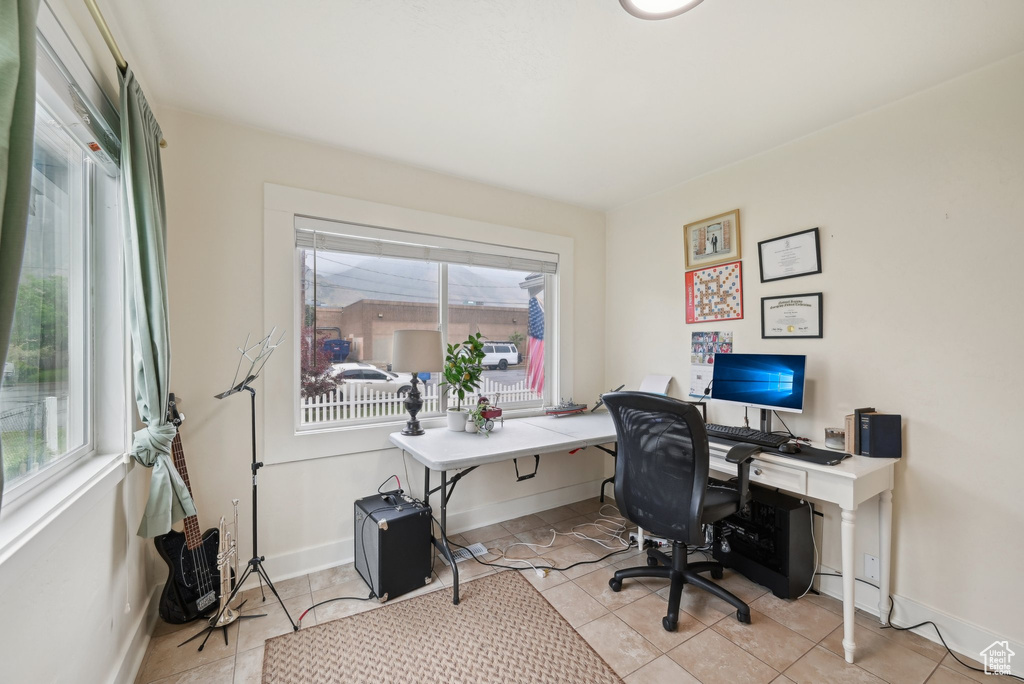 Office area with healthy amount of natural light, baseboards, and light tile patterned floors