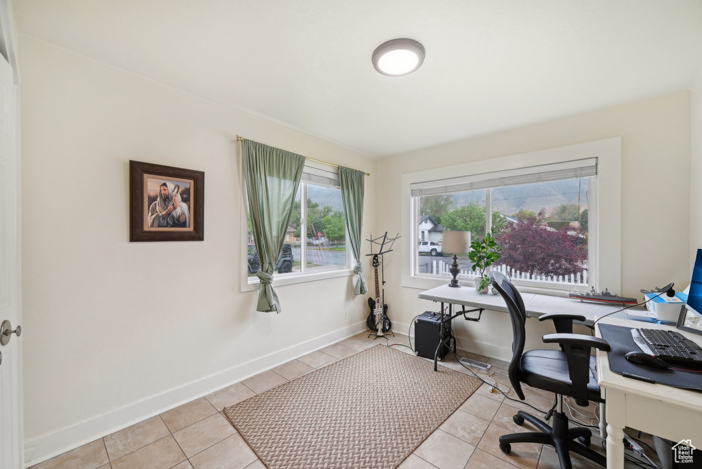 Office area featuring light tile patterned flooring and baseboards