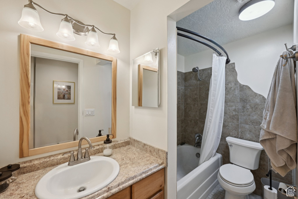 Bathroom with shower / bath combo, vanity, and toilet
