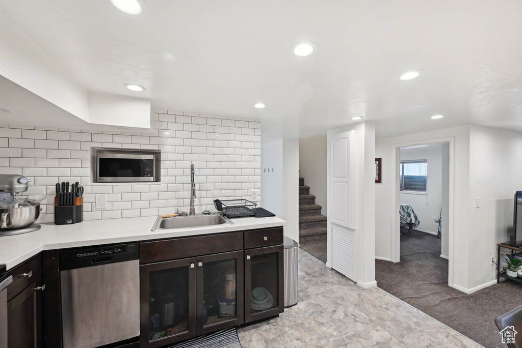 Kitchen featuring dishwasher, a sink, recessed lighting, light countertops, and backsplash
