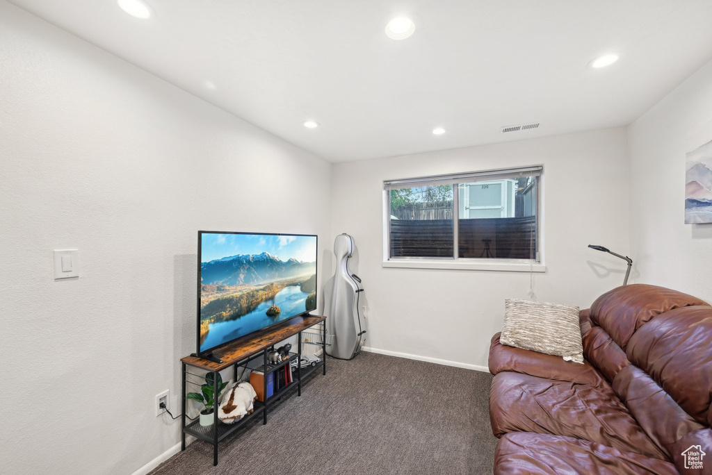 Carpeted living area featuring recessed lighting and baseboards