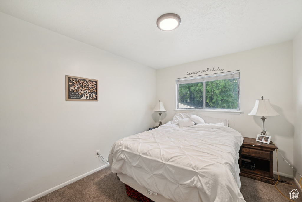 Bedroom featuring carpet floors and baseboards