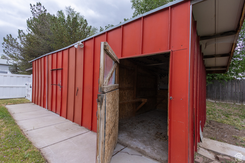 View of outdoor structure featuring fence and an outdoor structure