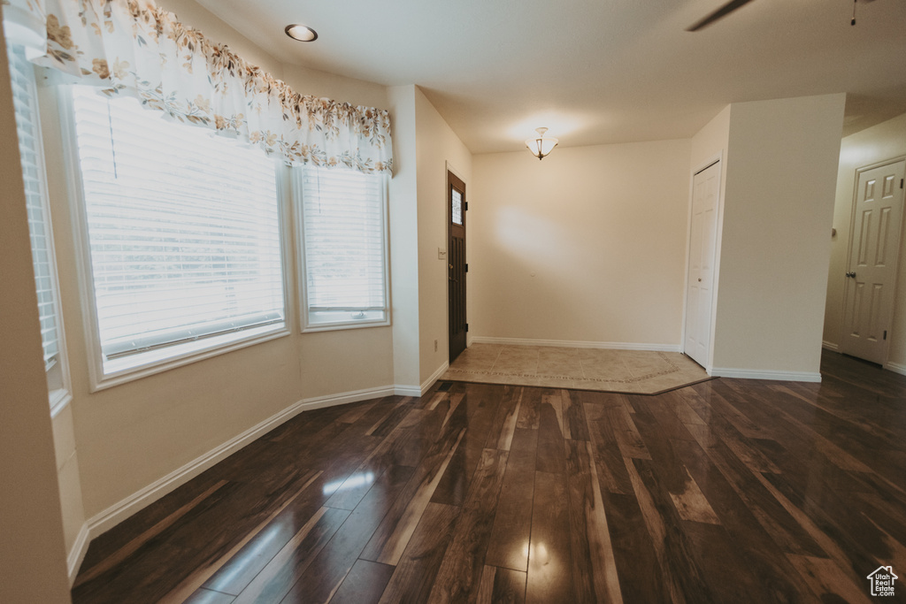 Unfurnished dining area featuring wood finished floors, baseboards, and a ceiling fan