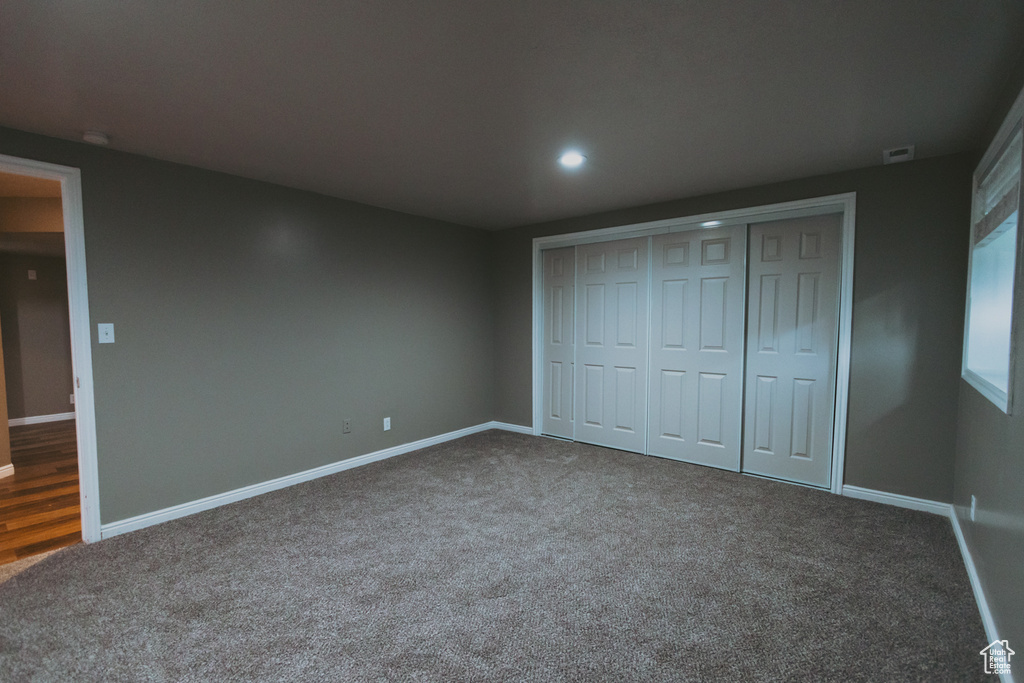 Unfurnished bedroom with carpet, baseboards, recessed lighting, and a closet