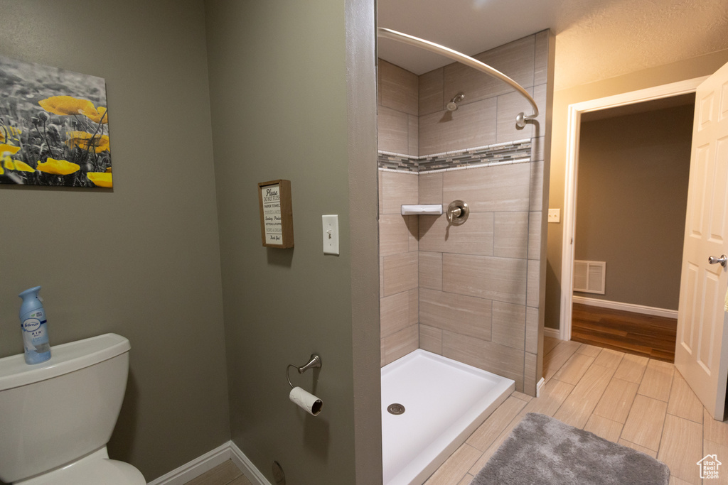 Bathroom with a shower stall and toilet