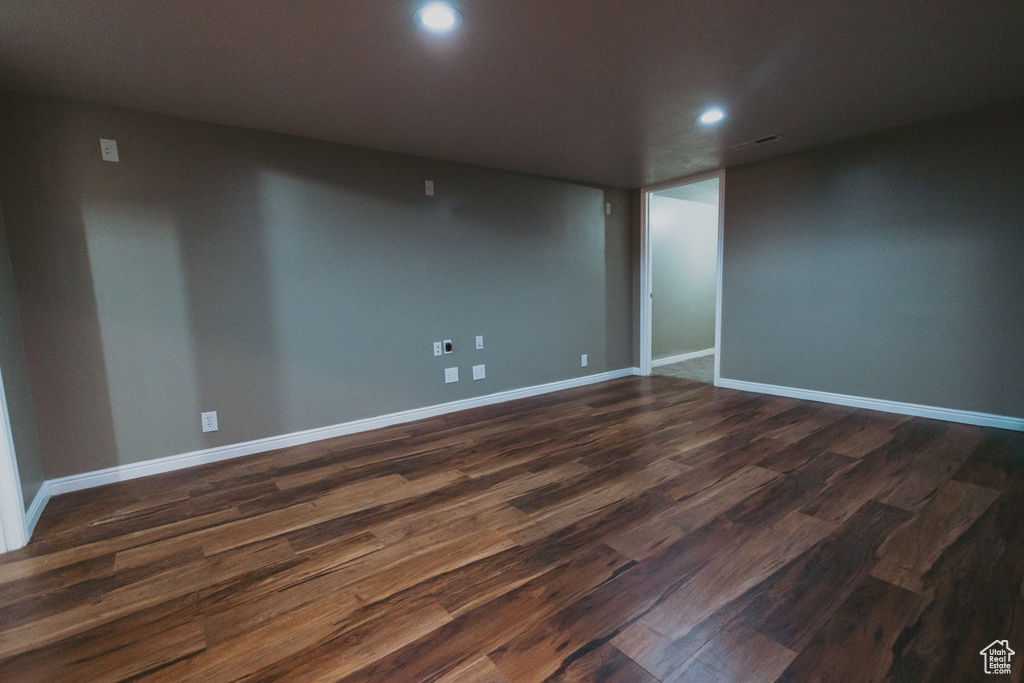 Unfurnished room with recessed lighting, dark wood-style flooring, and baseboards